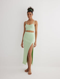 Front View: Model in Jules Mint Green Skirt - MOEVA Luxury Swimwear, Knitted Skirt, Button Detail Throughout, Side Assymmetrical Skirt, Elasticated Waistband, Front Slit, MOEVA Luxury Swimwear