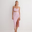 "Jules pink skirt on a model, front view showing the elegant button accents and hemline."