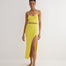 "Front view of a model in the Jules Yellow Skirt, highlighting the asymmetrical design and button accents."