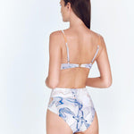 "Model wearing the Kai Blue Abstract Swimsuit from the back, highlighting the adjustable straps and tie-back with gold clasps."
