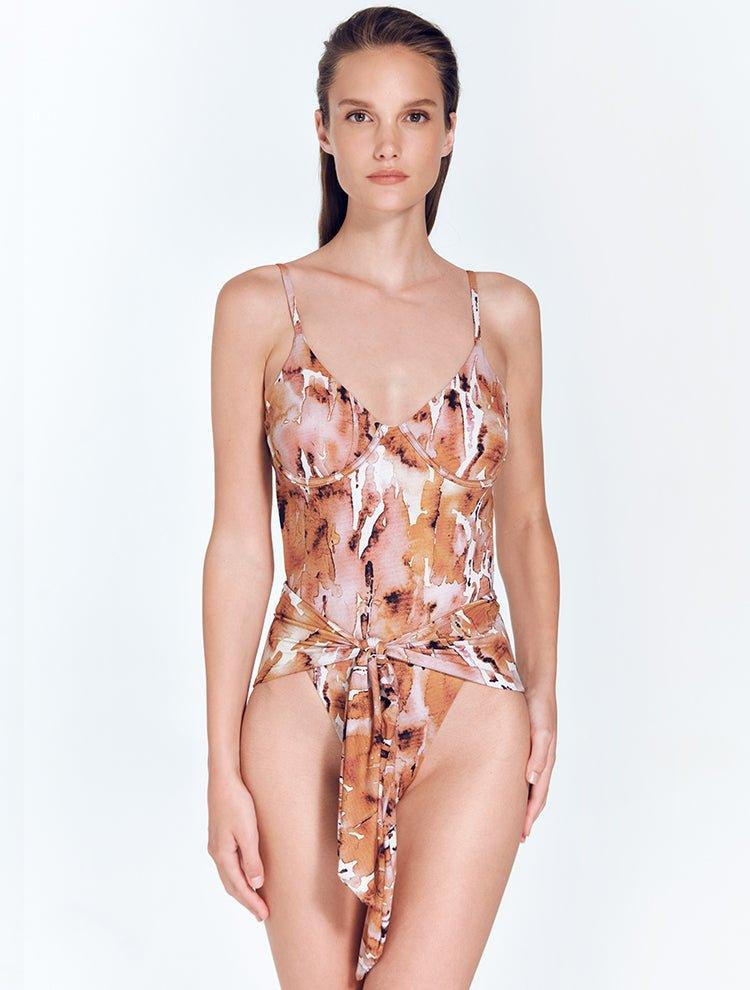 "Model wearing Kai Floral Abstract Swimsuit, showing underwired top and tie-front detail with high-cut legs."