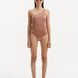 Model showcasing the Kaimana Brown Swimsuit, highlighting the one-shoulder design and gold sculpted accessory.