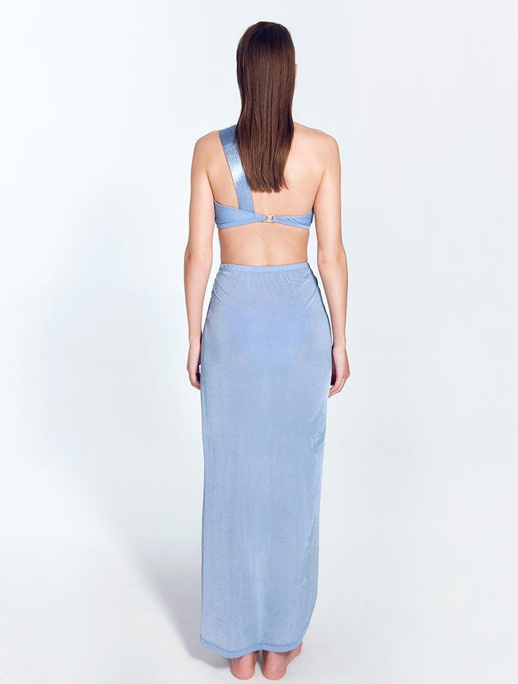 "Model wearing Kalea Blue Skirt from the back, featuring the lightweight, flowy fabric and ankle-length cut with a concealed side zip and elegant wrap-effect design."