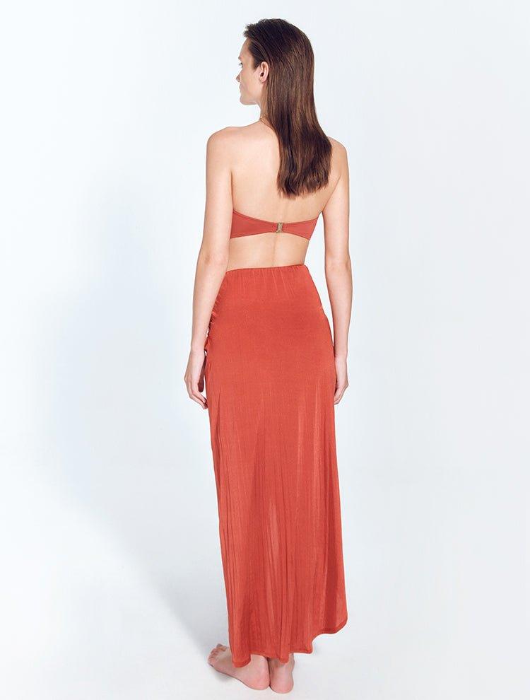 "Model wearing Kalea Red Ochre Skirt from the back, highlighting the concealed side zip fastening and flowing, lightweight fabric."