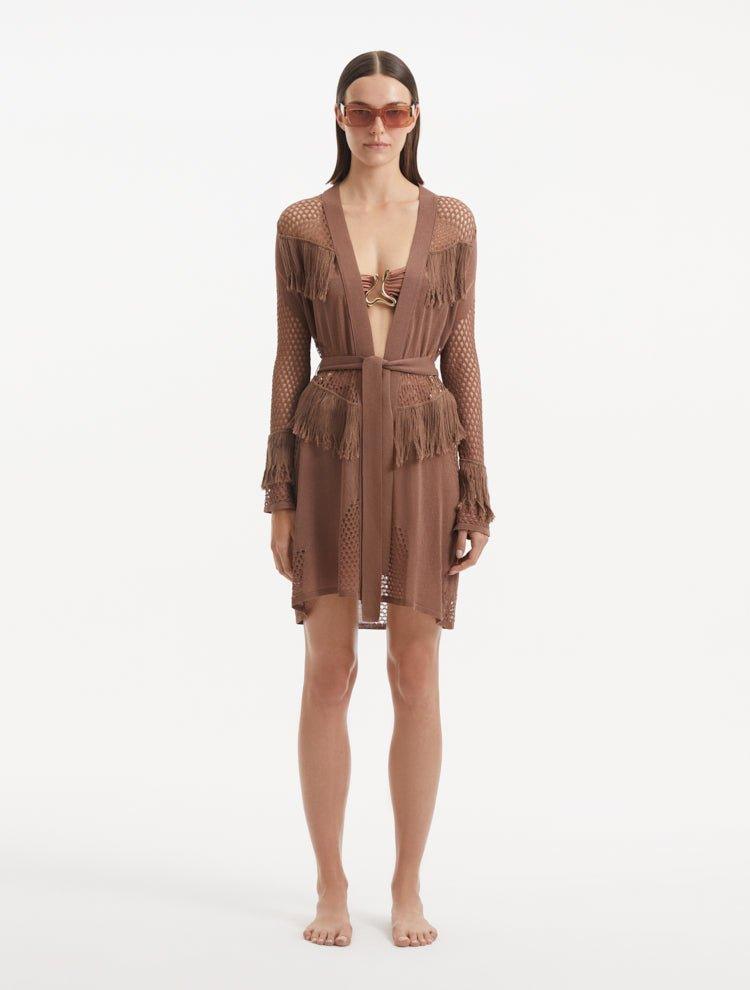 "Model showcasing the Kenga Brown Kaftan from the front, highlighting the knee-length cut, hand-knitted openwork pattern, and fringe detailing."
