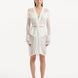 "Model showcasing the Kenga White Kaftan from the front, highlighting the knee-length cut, intricate knitted texture, and cascading fringe details."
