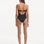 Back view of the Kenna Black Swimsuit, highlighting the gold clasps and full bottom coverage.