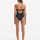 Back view of the Kenna Black Swimsuit, highlighting the gold clasps and full bottom coverage.