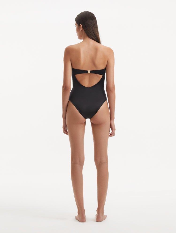 Back view of the Kenna Black Swimsuit, highlighting the gold clasps and full bottom coverage.