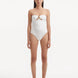 Model showcasing the Kenna White Swimsuit with its elegant strapless neckline and gold sculpted accessory detail.