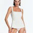 "Model wearing Kimberley Seersucker White Swimsuit with a skirted design and fabric-covered buttons, showcasing the front view."