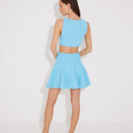 "Back view of the Lanao blue cut-out knitted dress displaying the open back with gold accessory and flared hem for a glamorous summer style."