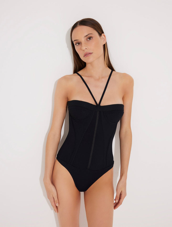 Front View: Model in Lia Black Swimsuit - MOEVA Luxury Swimwear, Corset Silhouette, Figure Sculpting, Stitching Details, Underwired Cups, Centrally Placed Adjustable Straps, MOEVA Luxury Swimwear 