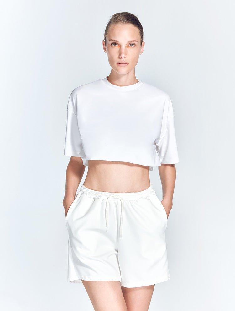 "Front view of Linette White Shorts showcasing intricate mesh detailing and a geometric design. The shorts are made from stretchable fabric, ensuring a comfortable and flexible fit. "