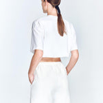 "Back view of the Linette White Shorts featuring a minimalist design. The shorts have a clean, white finish with a smooth waistband and no visible pockets or embellishments. "