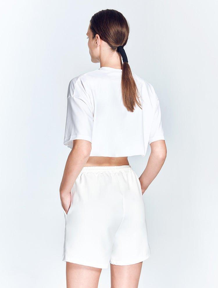 "Back view of the Linette White Shorts featuring a minimalist design. The shorts have a clean, white finish with a smooth waistband and no visible pockets or embellishments. "