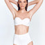 "Model wearing the Livia White Bikini Bottom from the front. The high-rise design and sculpting stretch fabric provide a smooth and elegant fit.."