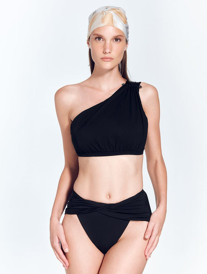 Front View: Model in London Black Bikini Top - MOEVA Luxury Swimwear, One Shoulder, Ruched Top, Matte Satin Contrast, MOEVA Luxury Swimwear