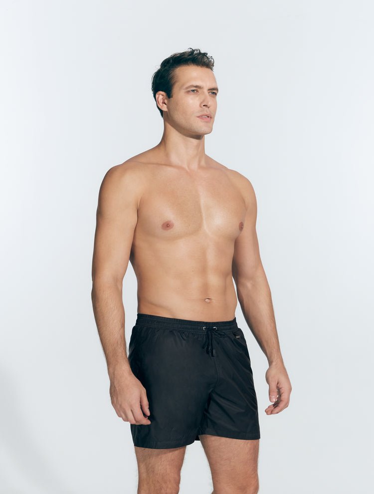 Front View: Model in Louis Black Shorts - MOEVA Luxury Swimwear, Close Fitting, Lightweight Fabric with Quick Drying, Pockets at the Front, Drawstring Waist, Quick Dry,  MOEVA Luxury Swimwear