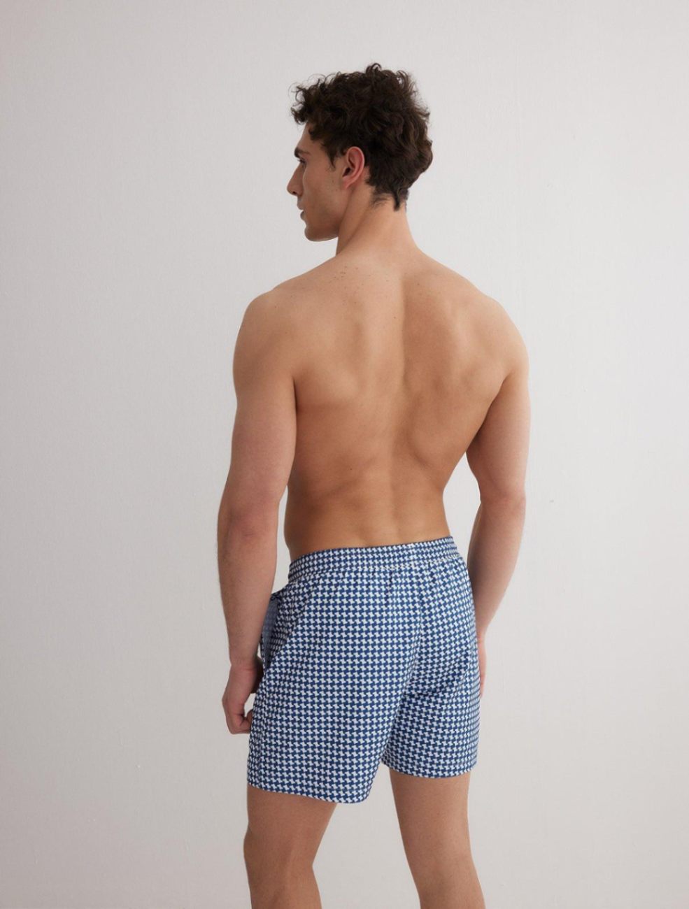Back View: Model in Louis Blue Mirage Shorts - MOEVA Luxury Swimwear, Men	Swim Shorts, Nikel, Mid Length Swim Shorts, Fully Lined, Slim Fit, Quick Dry, MOEVA Luxury Swimwear