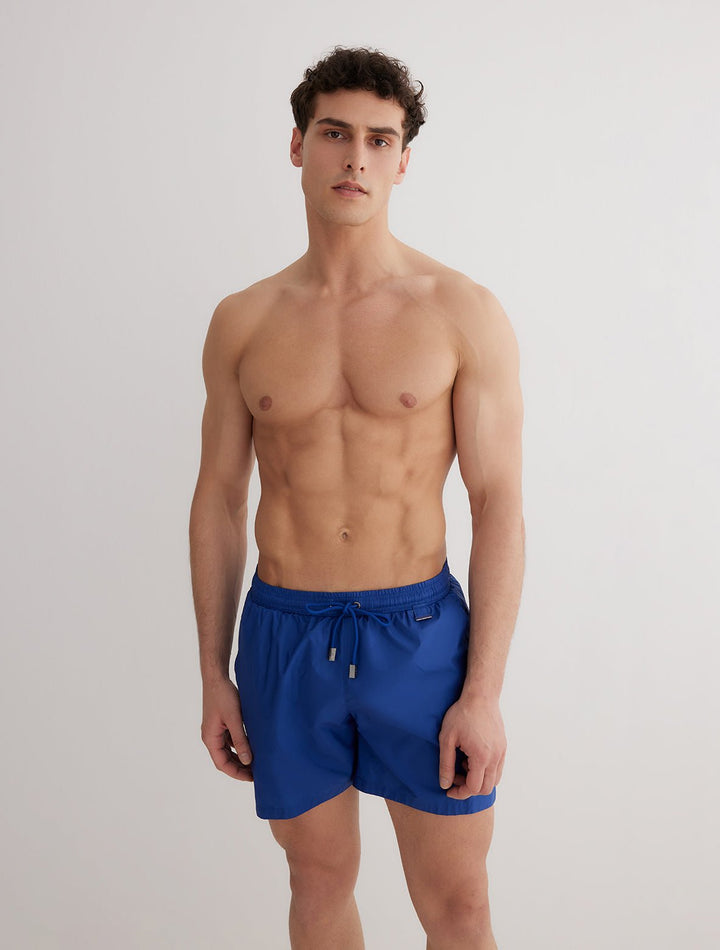 Front View: Model in Louis Dark Blue Shorts - MOEVA Luxury Swimwear, Close Fitting, Lightweight Fabric with Quick Drying, Pockets at the Front, Drawstring Waist, Quick Dry,  MOEVA Luxury Swimwear