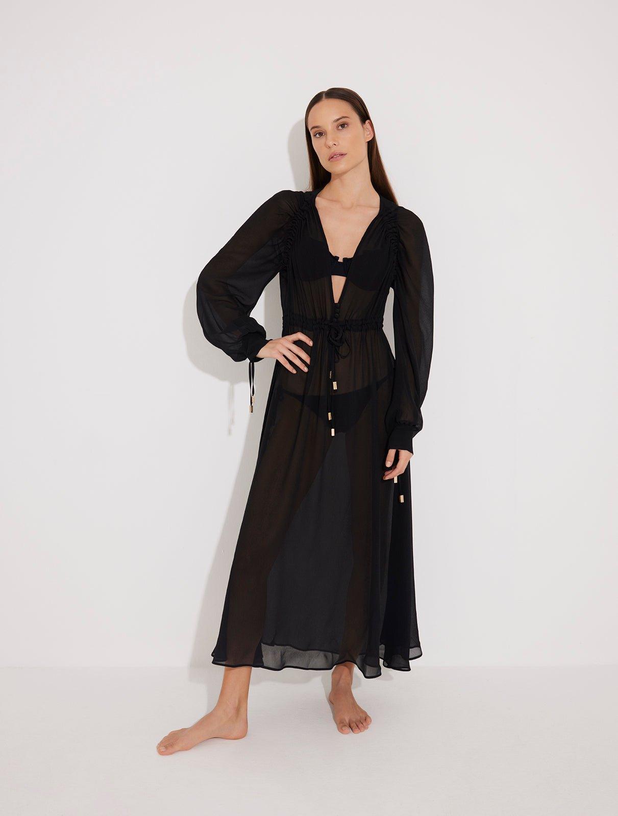 "Front view of a model wearing the Lula Black Maxi Dress, showcasing its classic silhouette and blouson sleeves."