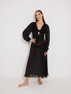 "Front view of a model wearing the Lula Black Maxi Dress, showcasing its classic silhouette and blouson sleeves."