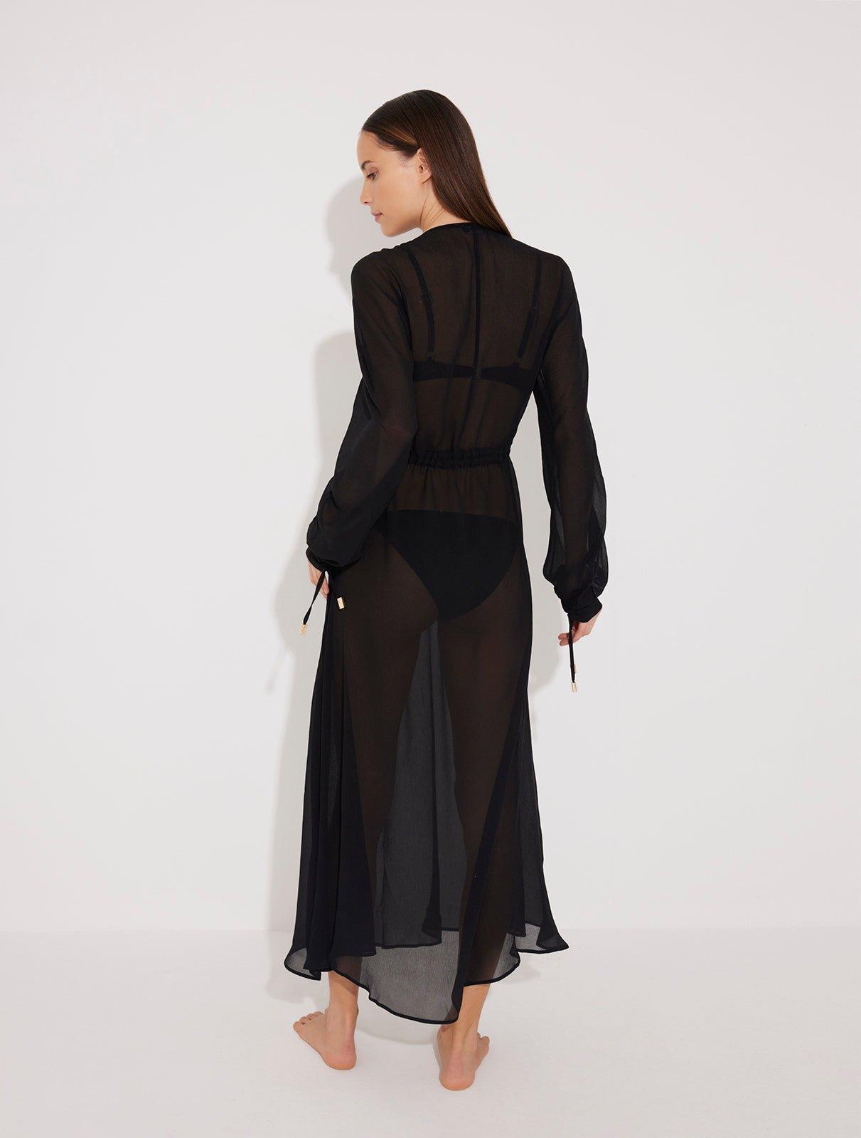 "Back view of the Lula Black Maxi Dress, highlighting the deep v-neckline and sheer silk fabric."