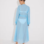 "Bacl view of the Lula Blue Silk Dress on a model, emphasizing its loose fit and adjustable neckline."