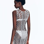 "Model wearing Maggie Silver Dress from the back view. The dress features a scoop neckline, body-firming crochet fabric,"