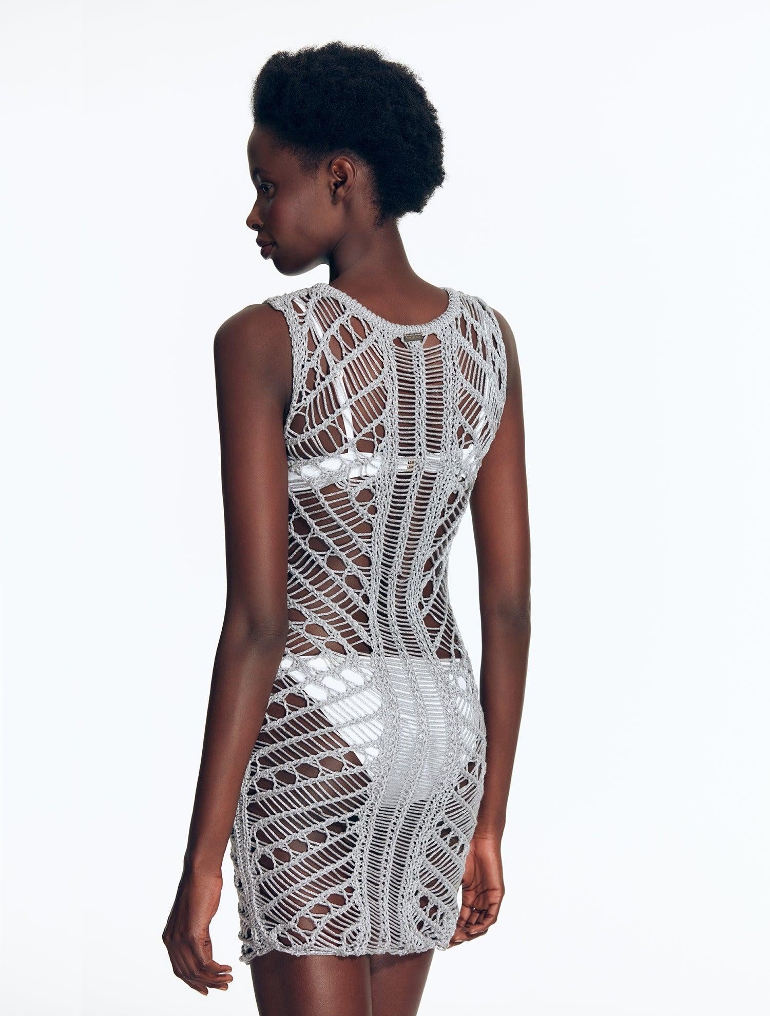 "Model wearing Maggie Silver Dress from the back view. The dress features a scoop neckline, body-firming crochet fabric,"
