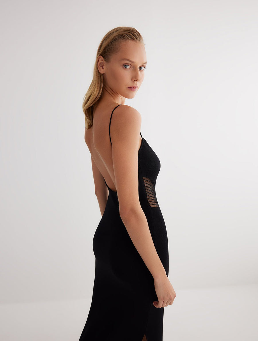 Side View: Model in Malin Black Dress - Scoop Neckline Knitted Dress, MOEVA Luxury Swimwear