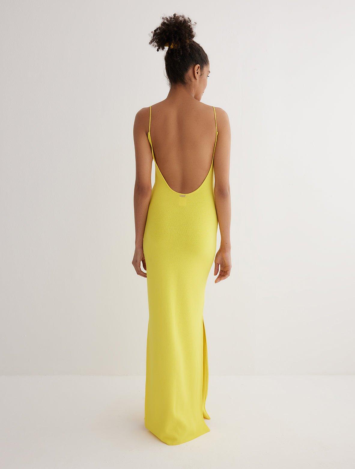 "Back view of the Malin yellow dress, emphasizing the sleek fit and knitted design."