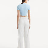 "Manami White Pants from the back, showcasing the high waist and hidden zip. The uninterrupted flow of fabric and relaxed fit are clearly visible."