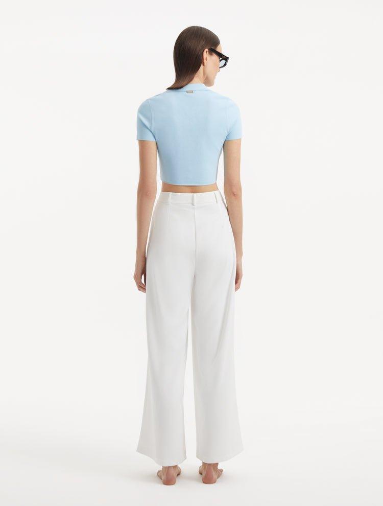 "Manami White Pants from the back, showcasing the high waist and hidden zip. The uninterrupted flow of fabric and relaxed fit are clearly visible."