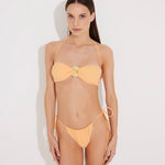 Front View: Model in Marcella Orange Bikini Top - Bandeau Style, Twisted Gold Accessory Detail, Ruched Detailing, Removable Padding and Straps, MOEVA Luxury Swimwear  