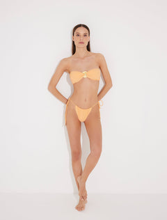 Front View: Model in Marcella Orange Bikini Bottom - MOEVA Luxury Swimwear, Brazilian Bottom, Low Rise, Straps Ties at the Side, Small/Minimum Coverage, MOEVA Luxury Swimwear  