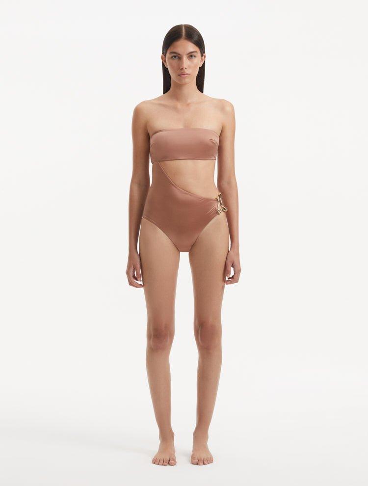  Model showcasing the Marilla Brown Swimsuit, highlighting the high-waist style and strapless design with cut-out detail.