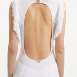 " Close-up of the Maris White Dress, capturing the texture of the mesh knit, the gold clasps, and the fringes at the hem."