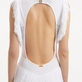 " Close-up of the Maris White Dress, capturing the texture of the mesh knit, the gold clasps, and the fringes at the hem."
