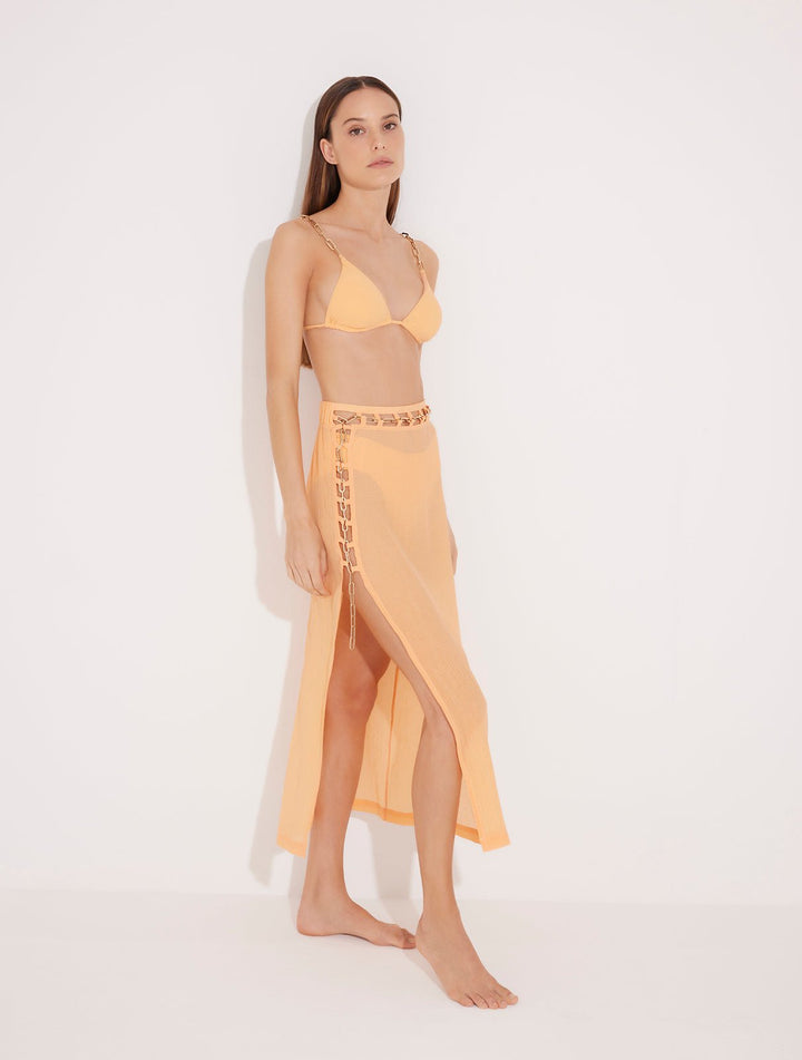 Front View: Model in Maritza Orange Skirt - MOEVA Luxury Swimwear, Side Slit, High Rise, Elastic Waistband, Geometrical Chain Belt, MOEVA Luxury Swimwear