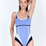 "Model wearing the Martina Blue/Black/White Swimsuit from the front, showcasing the scoop neckline, high-cut leg, and geometric color-blocking design."