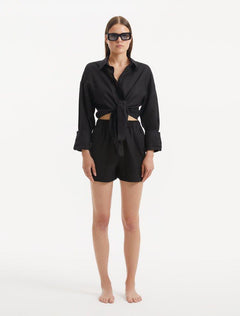 "The front view highlights the full-length sleeves with delicately buttoned cuffs and the shirt's sleek, deep black color, emphasizing its classic and sophisticated appearance."