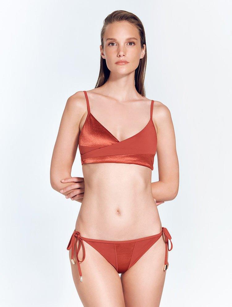 "Front view of model in Melody Red Ochre Bikini Top – Wrap-effect front with adjustable straps and gold clasps."