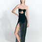  "Front view of a model wearing a black skirt with ruched detailing and a front slit. "