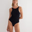 "Model wearing the Moa Black/Camel reversible bodysuit from the front, featuring a high neckline and thong-style cut"