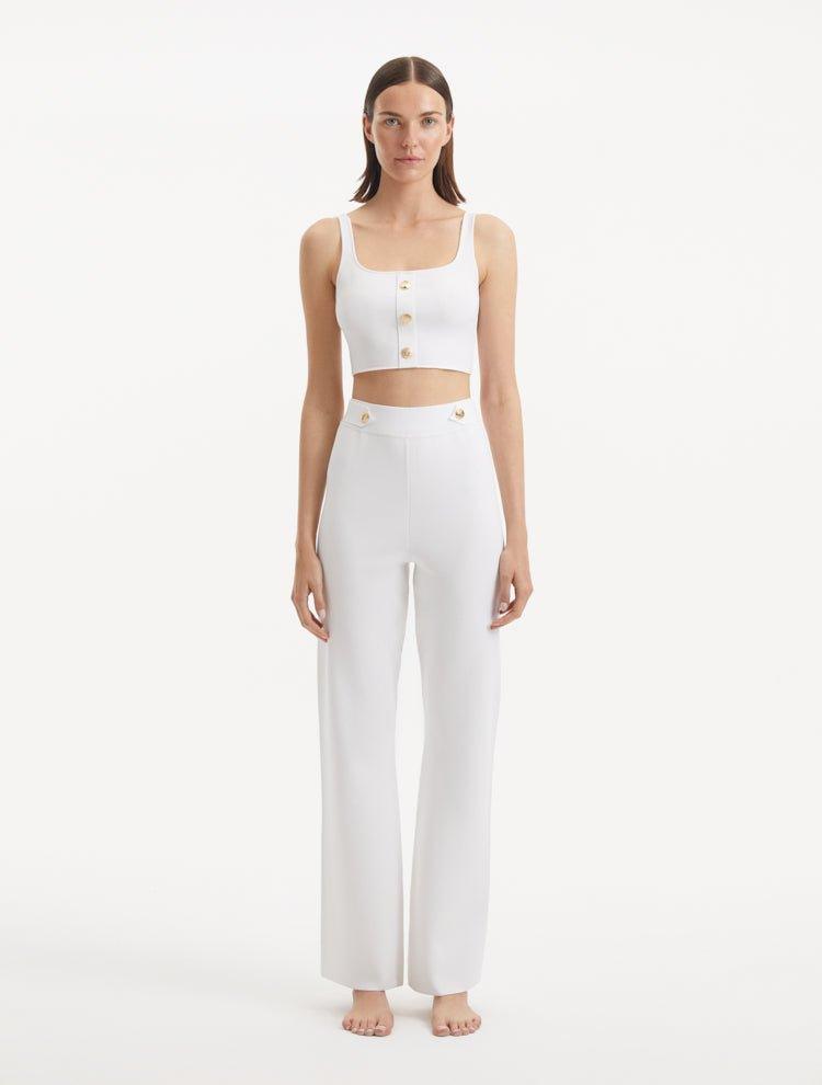 "Model wearing the Moira White Pants from the front, showcasing the high-waisted design and wide-leg cut. "