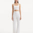 "Model wearing the Moira White Pants from the front, showcasing the high-waisted design and wide-leg cut. "