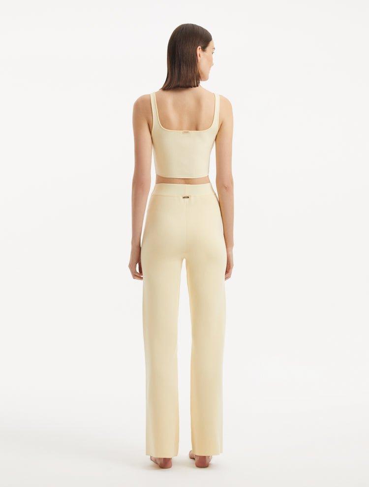 "Model wearing the Moira Yellow Pants from the back, focusing on the smooth, high-waisted style and wide-leg silhouette. "