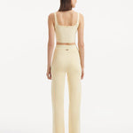 "Model wearing the Moira Yellow Pants from the back, focusing on the smooth, high-waisted style and wide-leg silhouette. "